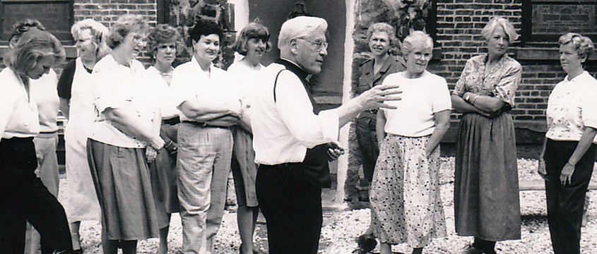 Father John talking with a group of volunteers outside the church